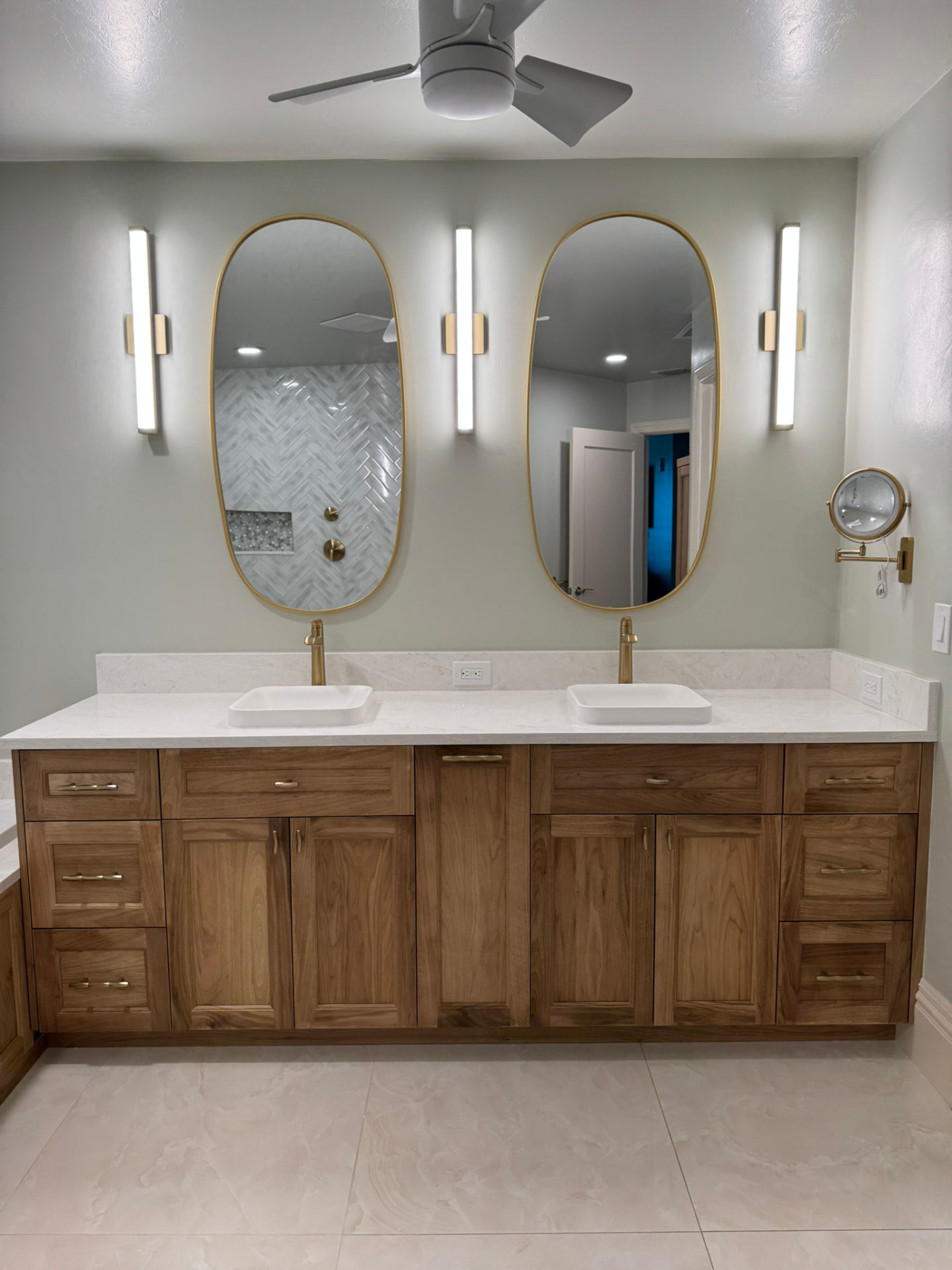 Custom natural walnut double bathroom vanity with quartz counter, vessel sinks, and brass hardware